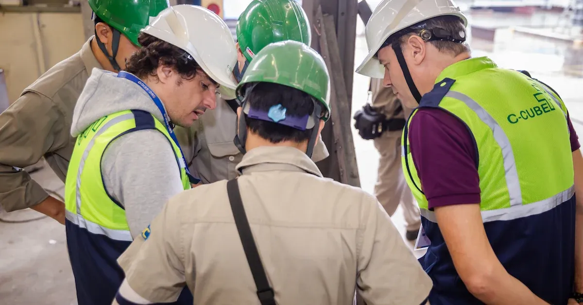 C-CUBE team members in high-visibility vests reviewing a project